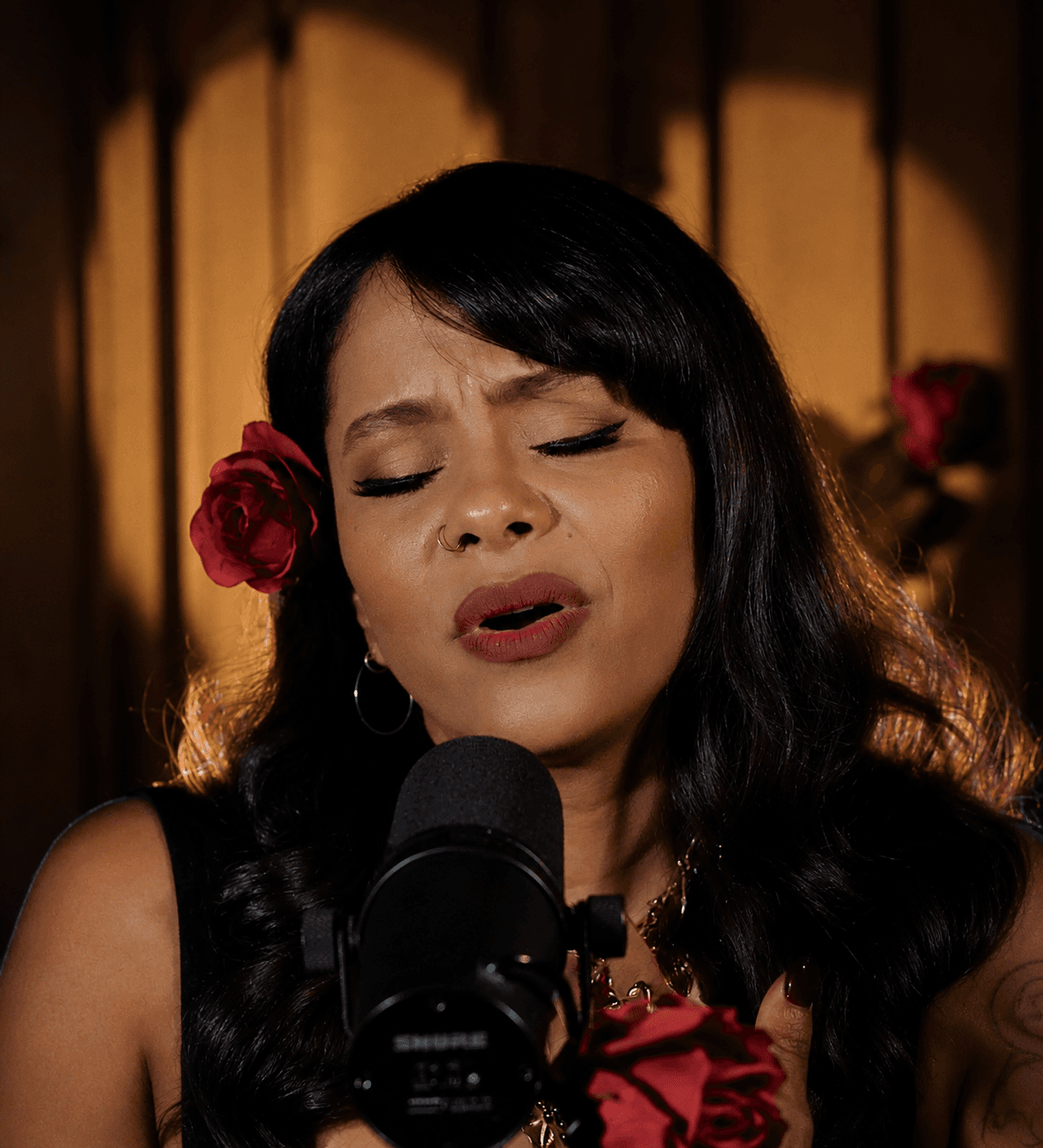 La vocalista de MarteOvenus canta con los ojos cerrados y una rosa roja en el cabello