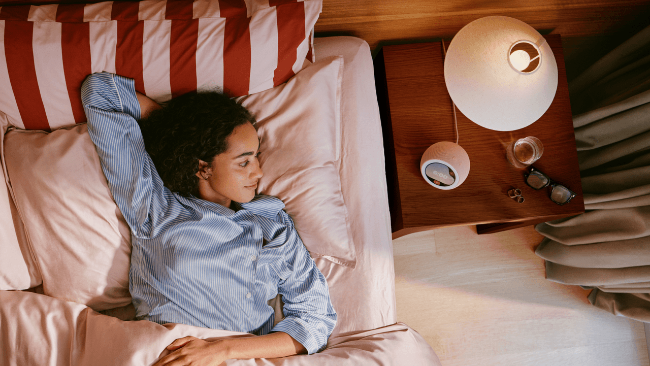 Una persona acostada mira el reloj inteligente Echo Time en la mesita de noche