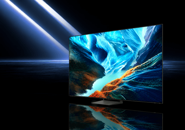 Televisor Samsung de pantalla grande sobre fondo oscuro con un paisaje de colores en pantalla