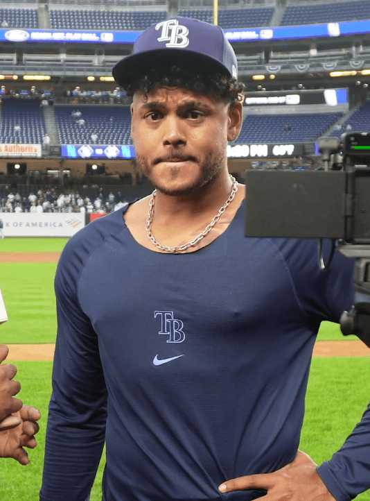 Freddy Peralta con gorra y camiseta de los Rays de Tampa Bay en el terreno