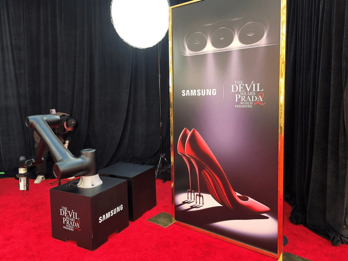 Estación de Samsung con un brazo robótico y un Galaxy S26 Ultra junto a la alfombra roja de El Diablo Viste a la Moda 2