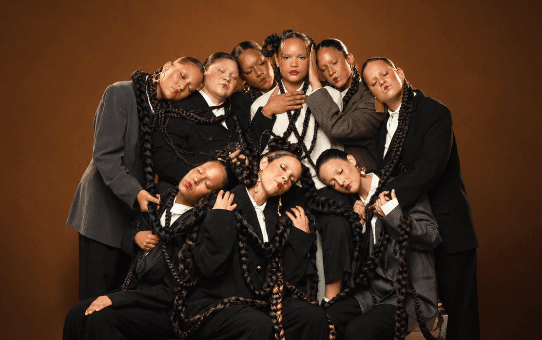 El elenco de «Todo estará bien», vestido de negro, en una foto de grupo sobre fondo ocre