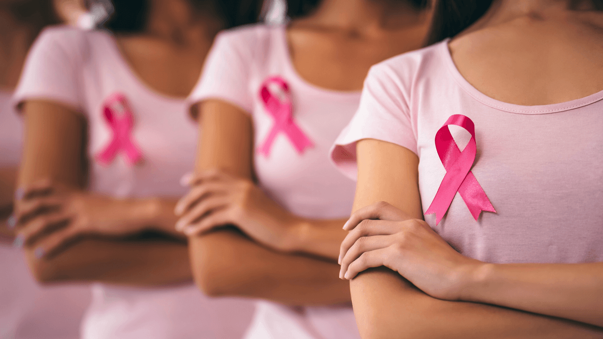 Mujeres con camisetas rosadas y el lazo de la prevención del cáncer de mama