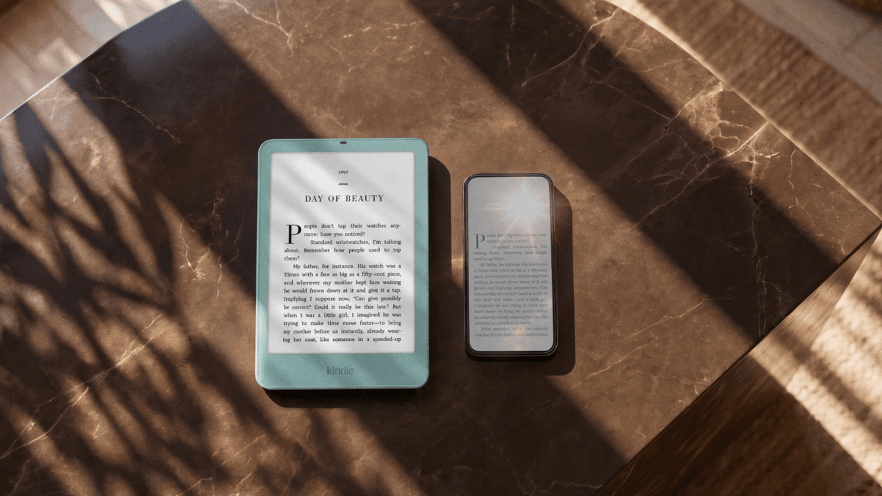 Kindle Paperwhite verde junto a un teléfono sobre una mesa de mármol, ambos con la misma página de un libro a pleno sol