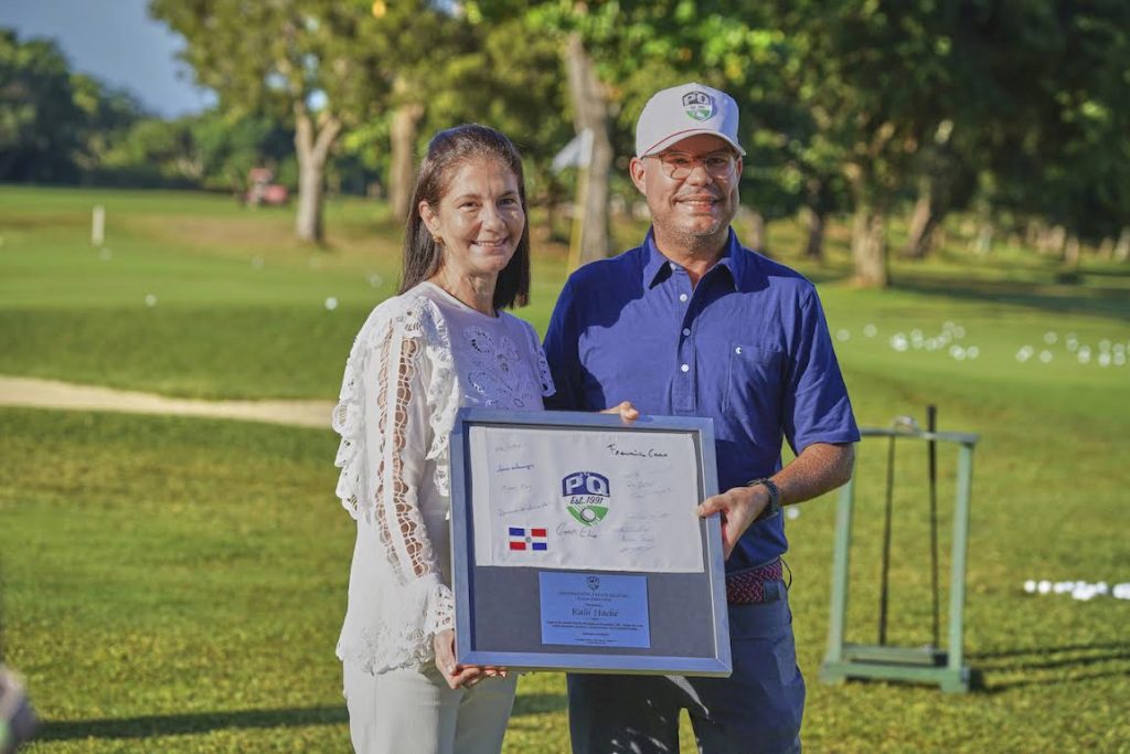 Maribel Haché recibiendo el reconocimiento a su padre Kalil Haché por manos de Miguel Roig