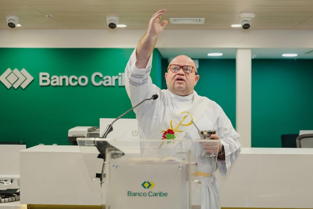 El diácono Pedro Mateo bendice la sucursal de Banco Caribe.